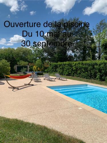 - une piscine avec 2 chaises et un hamac à côté dans l'établissement Chez clo, à Grièges