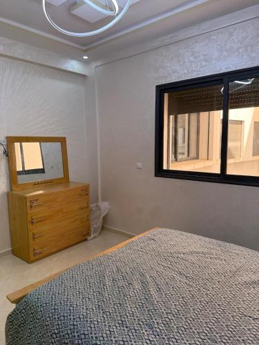 a bedroom with a bed and a mirror and a dresser at Comfortable and quiet apartment with Buzzinga in Bouznika