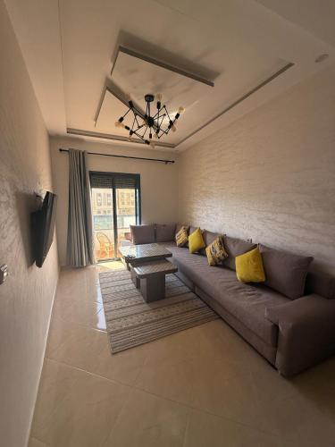 a living room with a couch and a table at Comfortable and quiet apartment with Buzzinga in Bouznika