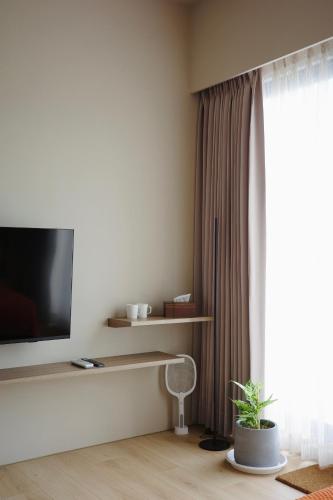a living room with a flat screen tv next to a window at Brewstay in Luye