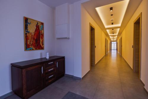 a hallway with white walls and a painting on the wall at Vinarija Aleksandrović Rooms in Topola