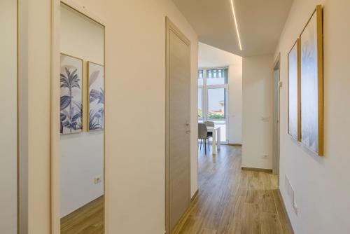 a hallway with white walls and a door with paintings at LOANO PERLA LIGURE in Loano