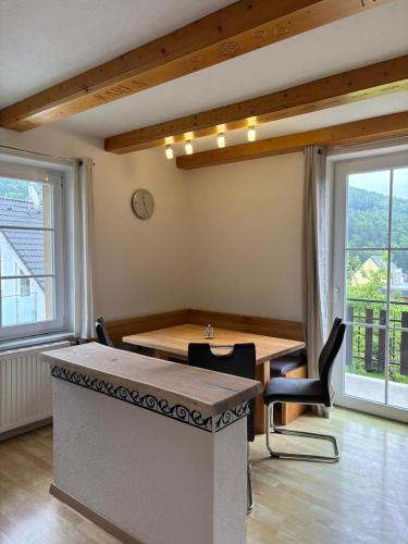 a dining room with a table and chairs and windows at Ferienwohnung am Labyrinth in Semriach