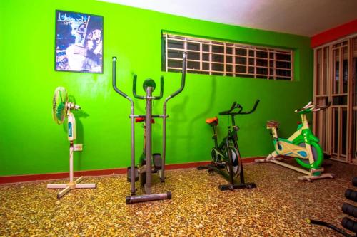 a gym with green walls and exercise bikes at Pacific Cottages and Guest House Jinja in Jinja
