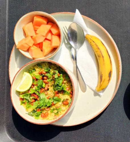 een bord met een kom eten en een kom fruit bij Rococo by Concordia Hospitality in Shillong