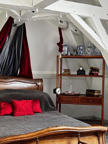- une chambre avec un lit en bois et des oreillers rouges dans l'établissement Chateau De Martigny, à Poisson