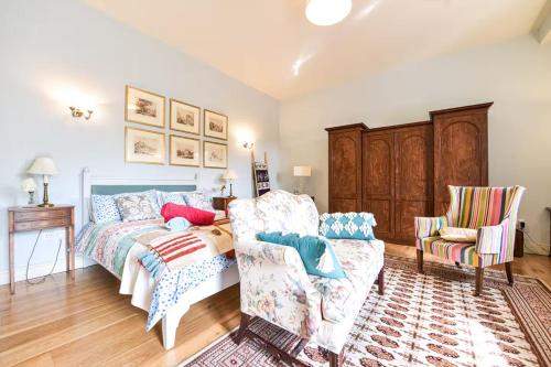 a bedroom with a bed and a couch and a chair at The Coach House at Moyglare Manor in Maynooth