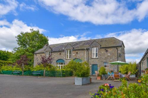 a large brick building with a table and an umbrella at The Coach House at Moyglare Manor in Maynooth