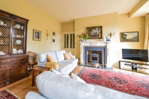 a living room with a couch and a fireplace at The Coach House at Moyglare Manor in Maynooth
