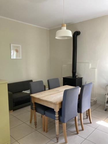 a dining room table with chairs and a stove at Au son des cloches in Zakharo
