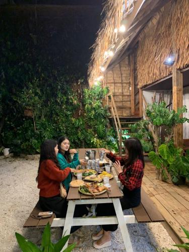a group of women sitting around a table eating food at Upes Garden Homestay Bien Ho in Bien Ho