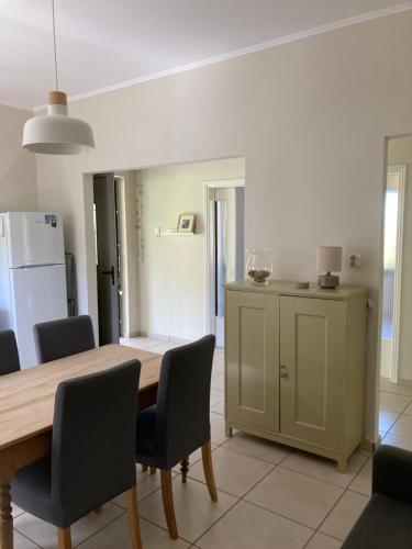 a kitchen with a table and chairs and a refrigerator at Au son des cloches in Zakharo