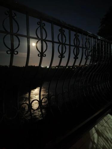 a metal fence with the moon in the background at Casa com Vista al Rio Paraná con Naturaleza y Comfort in Ciudad del Este