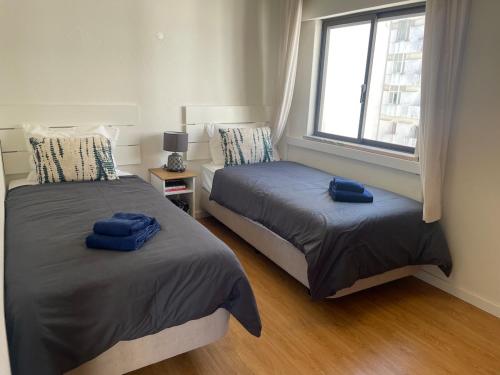 two beds in a room with a window at Apartment Ricardo-200m zum Meer in Armação de Pêra