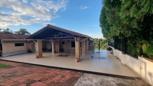 a house with a pavilion on a brick patio at Casa com Vista al Rio Paraná con Naturaleza y Comfort in Ciudad del Este
