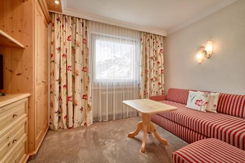 a living room with a couch and a table at Hotel Appartement Roggal in Lech am Arlberg