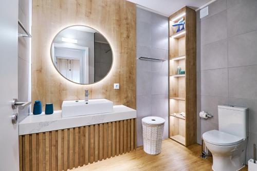 a bathroom with a sink and a mirror and a toilet at Apartment Ricardo-200m zum Meer in Armação de Pêra