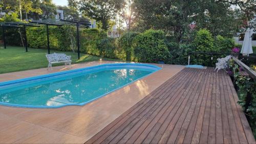 a swimming pool on a deck with a chair next to it at Casa com Vista al Rio Paraná con Naturaleza y Comfort in Ciudad del Este