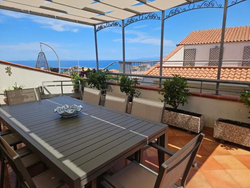 a table on a balcony with a view of the ocean at Casa Vacanze Le terrazze in Castel di Tusa