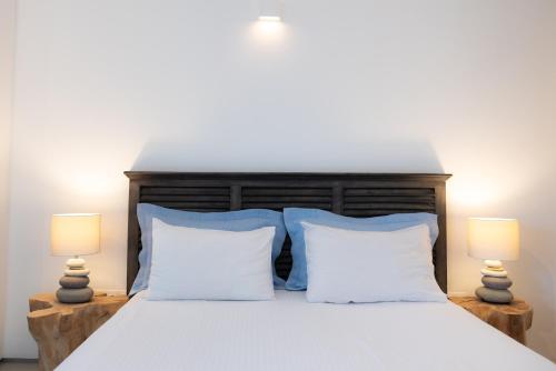 a bedroom with a white bed with two lamps at The Summit of Mykonos in Kalo Livadi