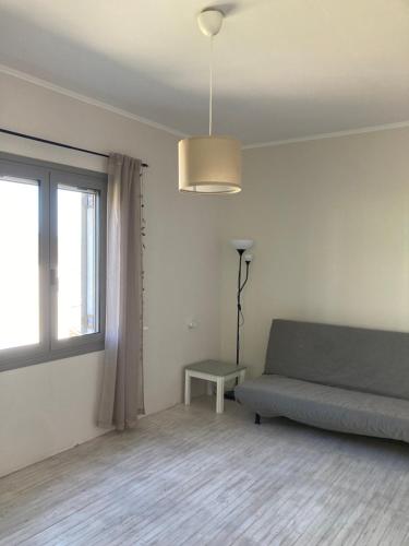 a living room with a couch and a window at Au son des cloches in Zakharo