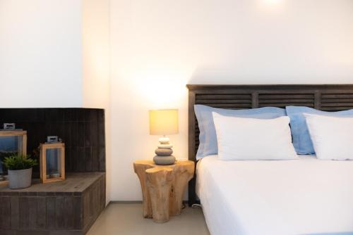 a bedroom with a bed and a lamp on a table at The Summit of Mykonos in Kalo Livadi