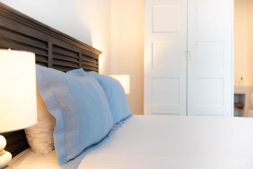 a bedroom with a bed with blue pillows at The Summit of Mykonos in Kalo Livadi