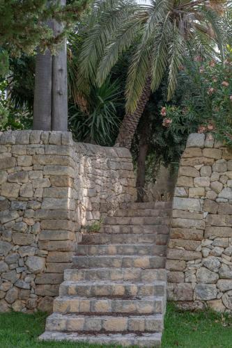 a stone retaining wall with a set of stairs at MILLE SUITE GARDEN in Noto