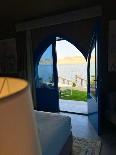 a bedroom with an open door with a view of the water at venecia Resort Fayoum in Al Ḩammām
