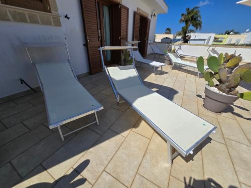 two blue and white benches on a patio at Lido Marini Rooms Affittacamere B&B in Lido Marini