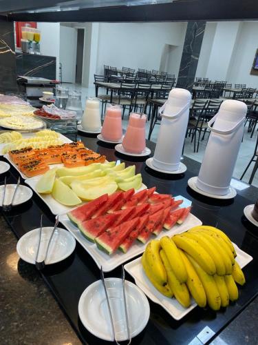 a table topped with different types of fruit on plates at Hotel Estação Express in Curitiba