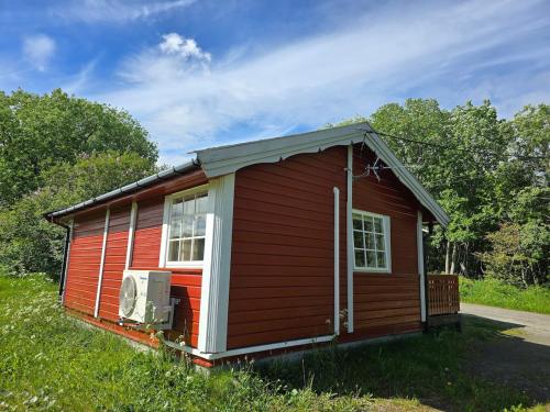 a small red cabin in a field of grass at The cabin in Saltstraumen in Saltstraumen