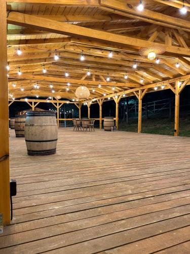 a wooden deck with a barrel and lights on it at Hotel COTA1110 in Beli Iskar
