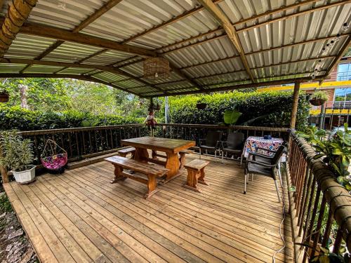 a wooden deck with a wooden table and a bench at Habitación para 4 con acceso al rio baño privado y wifi San Rafael Antioquia in San Rafael