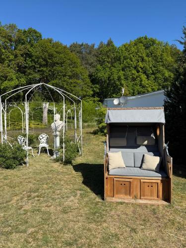 a bed in a field with a tent and a table at Ferienpark-Canow in Canow