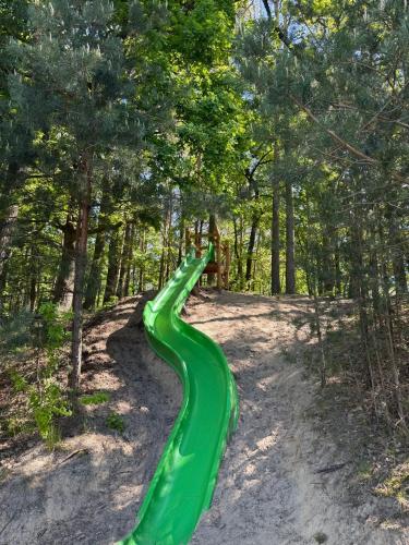 a green slide in the middle of a forest at Ferienpark-Canow in Canow