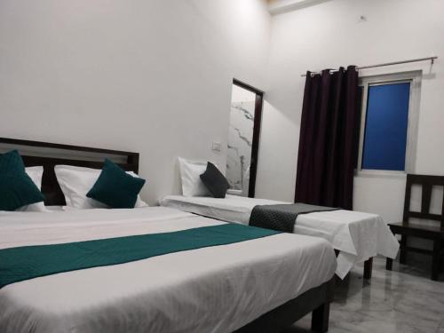 two beds in a room with a window at Hotel Shyalik Palace in Uttarkāshi