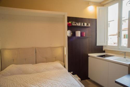 1 dormitorio con cama, lavabo y ventana en Minimal Signoria, en Florencia