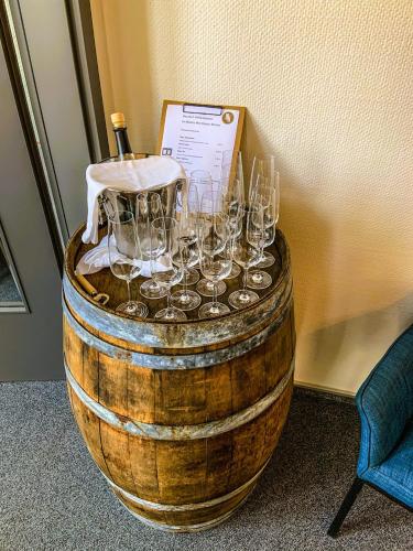 a barrel with wine glasses sitting on top of it at Moselhotel Weinhaus Simon `Sauna`Restaurant`ELadesäule in Wintrich