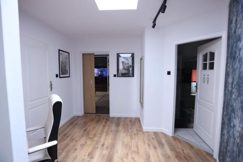 a hallway with white walls and wooden floors at The Castle Terrace Apartment 100m2 in Ciechanów