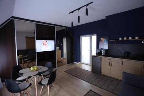 a kitchen with a table and chairs and a tv at The Castle Terrace Apartment 100m2 in Ciechanów