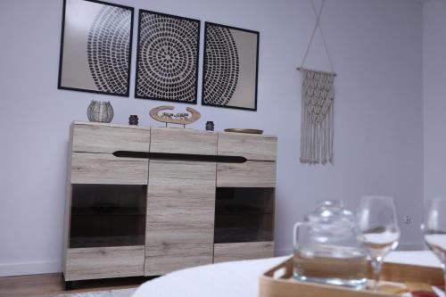 a wooden dresser in a dining room with wine glasses at The Castle Terrace Apartment 100m2 in Ciechanów