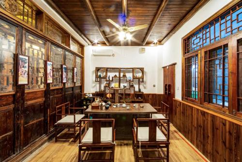a dining room with a table and chairs and windows at Yangshuo Scenic Mountain Retreat in Yangshuo