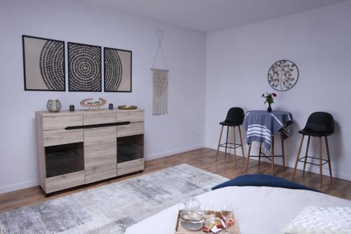 a living room with a wooden dresser and two stools at The Castle Terrace Apartment 100m2 in Ciechanów