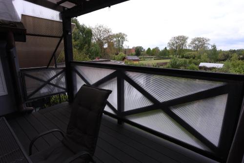 a chair on a balcony with a view of a body of water at The Castle Terrace Apartment 100m2 in Ciechanów