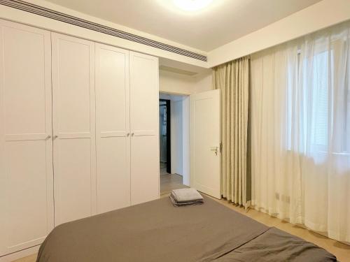 a bedroom with white cabinets and a bed at Pure Home-Near the Bund enjoys the beautiful scenery of the Bund 3-bedhome close to Yuyuan Garden Huaihai Road and Nanjing Road Pedestrian Street in Shanghai