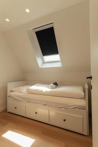 a bedroom with a bed with a window and a television at Villa 'La Mer Veille - Bécassine' in Oostduinkerke - Bad in Oostduinkerke