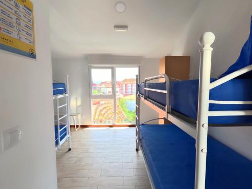 a room with two bunk beds and a window at Albergue de Sonia in Finisterre
