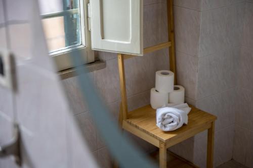 a bathroom with a shelf with toilet paper and a window at Palazzo Santori in Tivoli