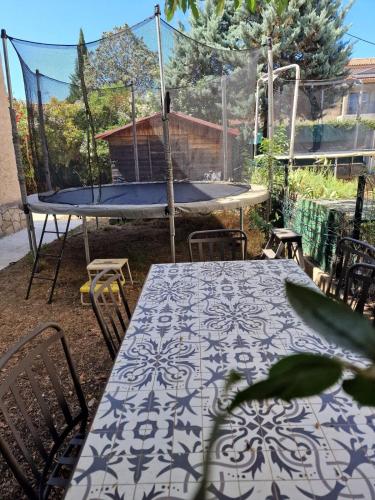 d'une terrasse avec une table, des chaises et un trampoline. dans l'établissement Family home with 6 bedrooms and pool, à La Celle-sous-Gouzon
